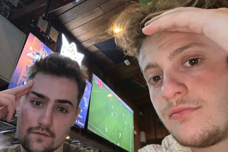 Founders Charlie and Dan head in hands in a bar